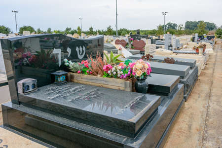 TEL AVIV - OCT. 26, 2019: Modern gravestones at  a Jewish cemetery in Israel at the outskirts of Tel Aviv.  Hebrew texts note the names and details of the deceased.のeditorial素材
