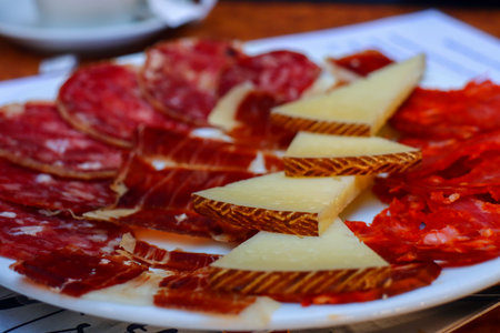 Appetizer plate with salami, jamon and cheese on tableの写真素材