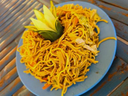 Fried noodle with vegetables on blue plate, Thai style.の写真素材