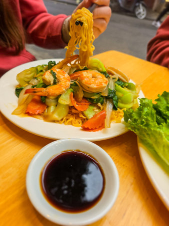 Fried noodle with shrimp and vegetables on the wooden table.の写真素材