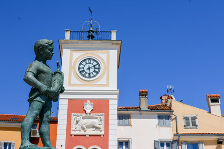 Statue of a man in front of the clock towerの写真素材