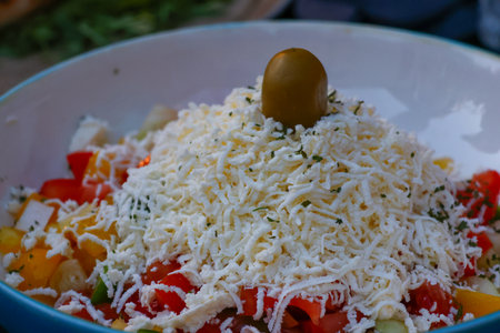 Close up of a bowl of salad with tomatoes, peppers and cheeseの写真素材
