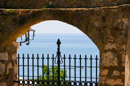 View of the sea through the window of an ancient castle in Rhodes, Greeceの写真素材