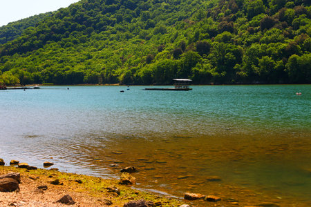 Beautiful mountain lake with clear blue water and green forest on the backgroundの写真素材