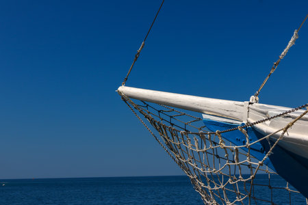 Fishing nets on the bow of a sailboat against the blue skyの写真素材