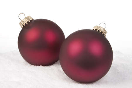 Two Red Christmas Bauble on a Snow backgroundの写真素材