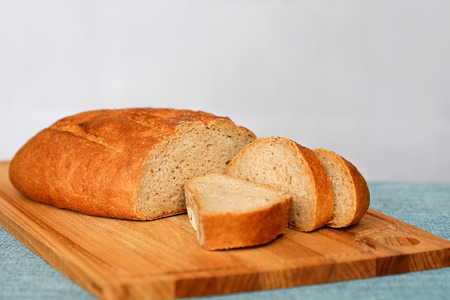 Rye fresh bread, fresh bread on the table in the dark interior. Bread with bran cut into slices on...