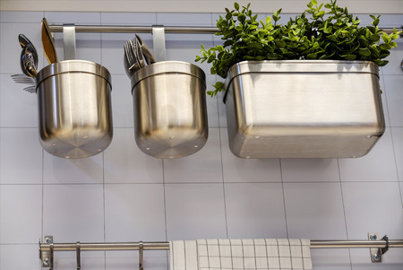 view of the kitchen counter with a cutting board, hanging on the wall several useful, buckets and bucket and skimmersの写真素材