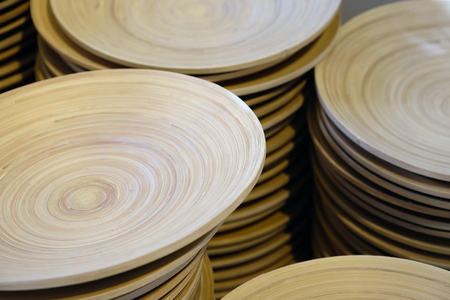 Brown wooden plates on the shelves close-up. Horizontal view from above. Stacked in a pile.の写真素材