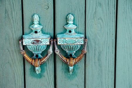 Ancient wooden gate with two door knocker ringsの写真素材