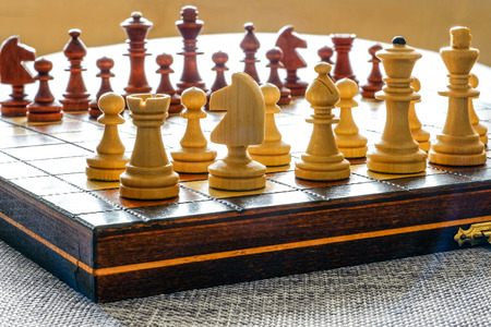 Color photo of chess Board and chess pieces, wooden chess pieces on the chessboard. White figures in...