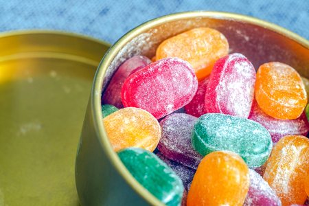 A jar of bright candy. The joy of children, a lot of sweets. Candy assorted colors. Caramel in powdered sugar. Colored candy. Red yellow green orange.の写真素材