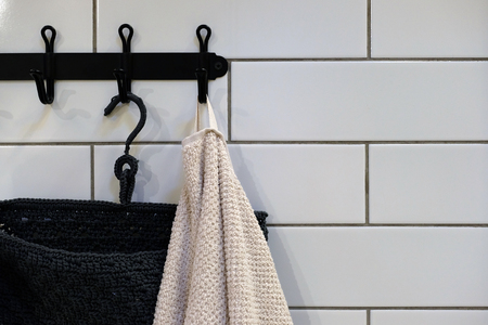 Clean colored towels hanging on the hanger in the bathroom. Towels are hung on hooks.の写真素材