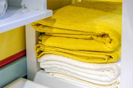 Clean colored towels hanging on the hanger in the bathroom. Towels are hung on hooks.の写真素材