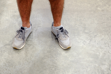 The man tied his shoelaces. Standing on a concrete floorの写真素材