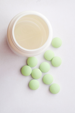 Medication pills. White pills, white background. A jar of pillsの写真素材