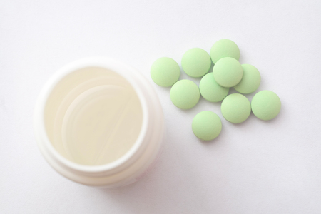 Medication pills. White pills, white background. A jar of pillsの写真素材