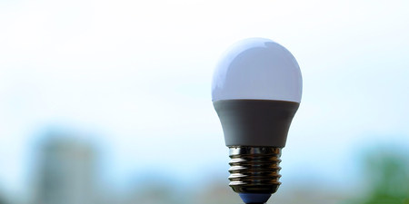 A small light bulb stands on a light background