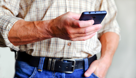 A man plays with his phone.の写真素材