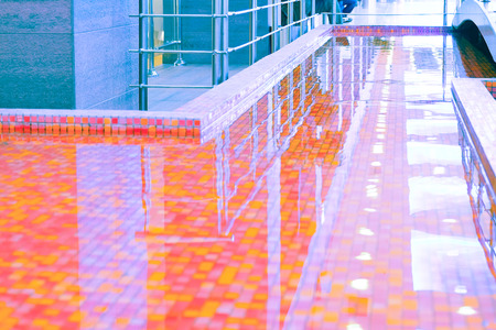 water in the pool with red-orange decorative tiles.の写真素材