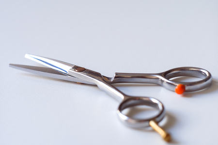 Scissors with finger rest on ring isolated on white backgroundの写真素材