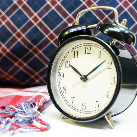 interior tartan and table clock next to pillows with checkered pattern.