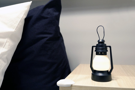 Top lights, bedside chest. A bedside rug. Bed soft blanket pillows. The atmosphere of coziness. Evening at home.の写真素材