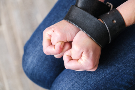 Domestic violence: woman tied with a belt. Aggression in the family. The husband is a sadist....