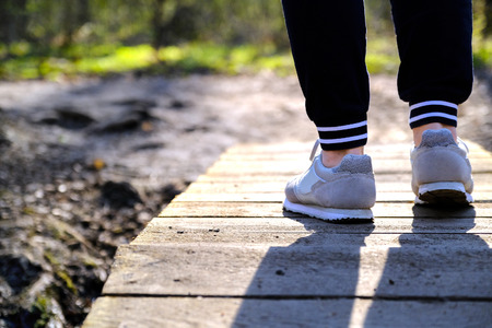 Jogging in sneakers on the bridge in the Park. Sport, Health and physical culture concept