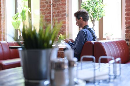 Interior cafe tables and chairs. Man photographer sitting at the table. Saint-Petersburg. Russia 06.02.2019のeditorial素材
