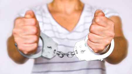 Detained woman at the police station. Handcuffs on the wrists of the detaineeの写真素材