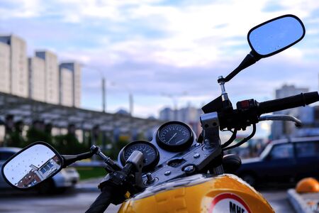 Evening. Throttle and brake on the handlebar of the motorcycle with chrome rear-view mirrors. Against the twilight skyの写真素材