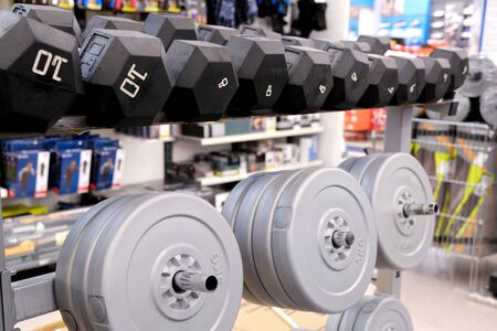 Dumbbells with different weights. Pancakes of different weights for the barbell . Located on the...