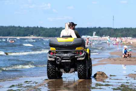 Quad bike on the beach on a dusty yellow background. Landscape blue background. Seascape. Summer landscape in the background. Saint-Petersburg. Russia. July 30 2020のeditorial素材