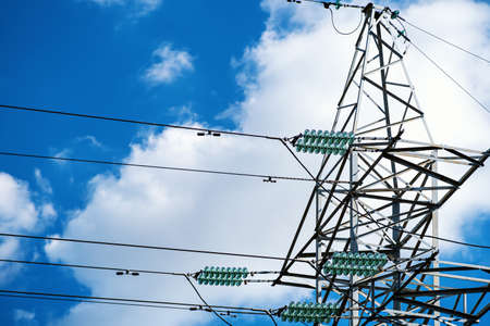 Towers with insulators on which the wires are fixed. High-voltage power transmission line. An extended structure of wires, cables and supports for the redistribution of electricity in the cityの写真素材