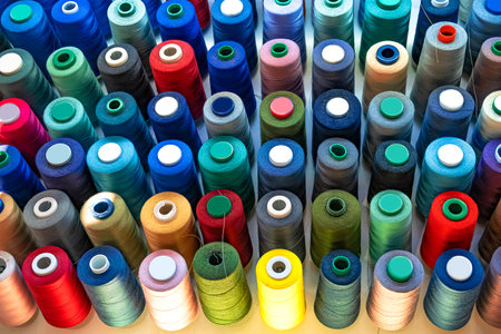 Atelier workshop. A set of colored threads for sewing on reels. A bunch of large multicolored spools...