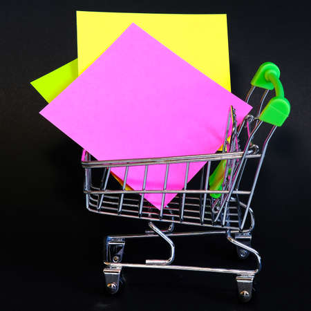 Colorful notes isolated on a black background. In the office basket.