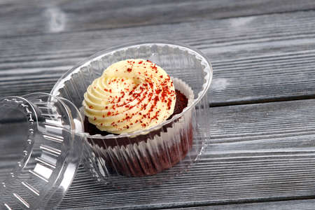 Sponge cake with Bizet and cinnamon crumbs on a saucer next to a disposable spoon and napkinの写真素材