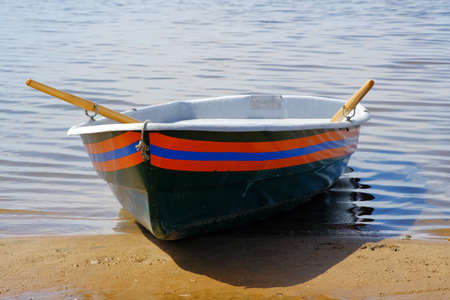 Sandbank. Rescue boat with oars on a blue background. Blue sky background. Transport background....