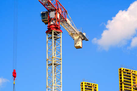 Crane and building under construction against blue skyの写真素材