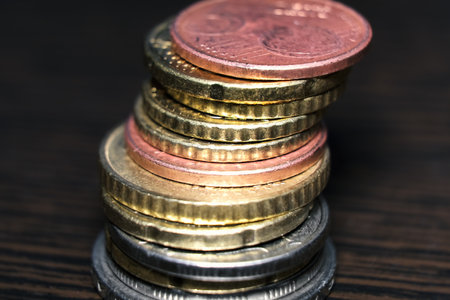 EU currency. Money and finance. Euro coins are stacked on top of each other in different positions....