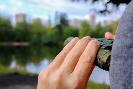 A Nature Observer with Binoculars enjoys the serene Water body and the beauty of natureの写真素材
