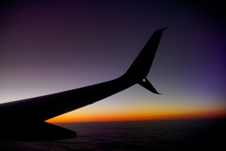 airplane wing flying at sunsetの写真素材