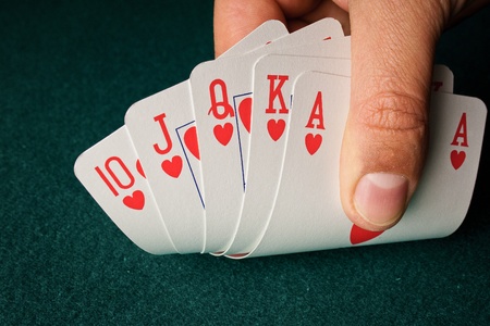detail of a royal flush on green table