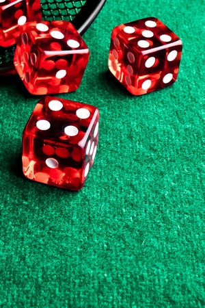 detail of red dice in corner in of a green tableの写真素材