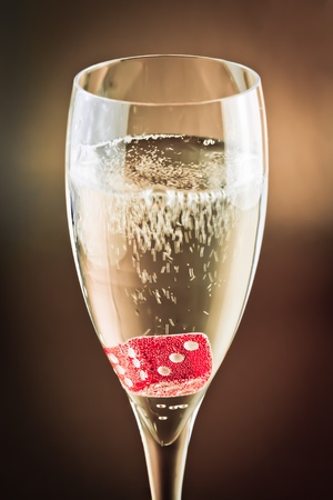 close up of  red dice in a champagne glass on shiny backgroundの写真素材