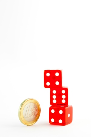 euro coin near a pile of red dice  on white background with space for textの写真素材