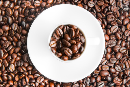 top view of a cup of coffee on beans coffee backgroundの写真素材