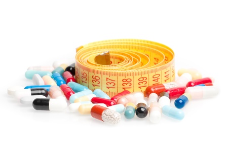 measuring tape with pills for dieting around on a white backgroundの写真素材
