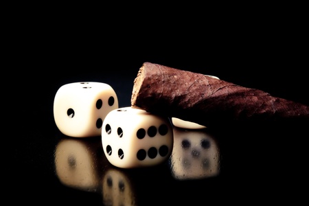 detail of white dice and cigar on old wood tableの写真素材